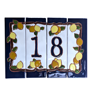 A set of ceramic house number tiles with a lemons and oranges design, dark blue edges, and a navy blue border.